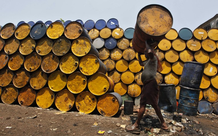 Image: A labourer carries an empty oil container at a wholesale fuel market in Kolkata